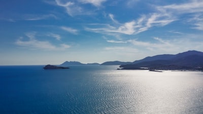 Ocean view with land formations under a blue sky.