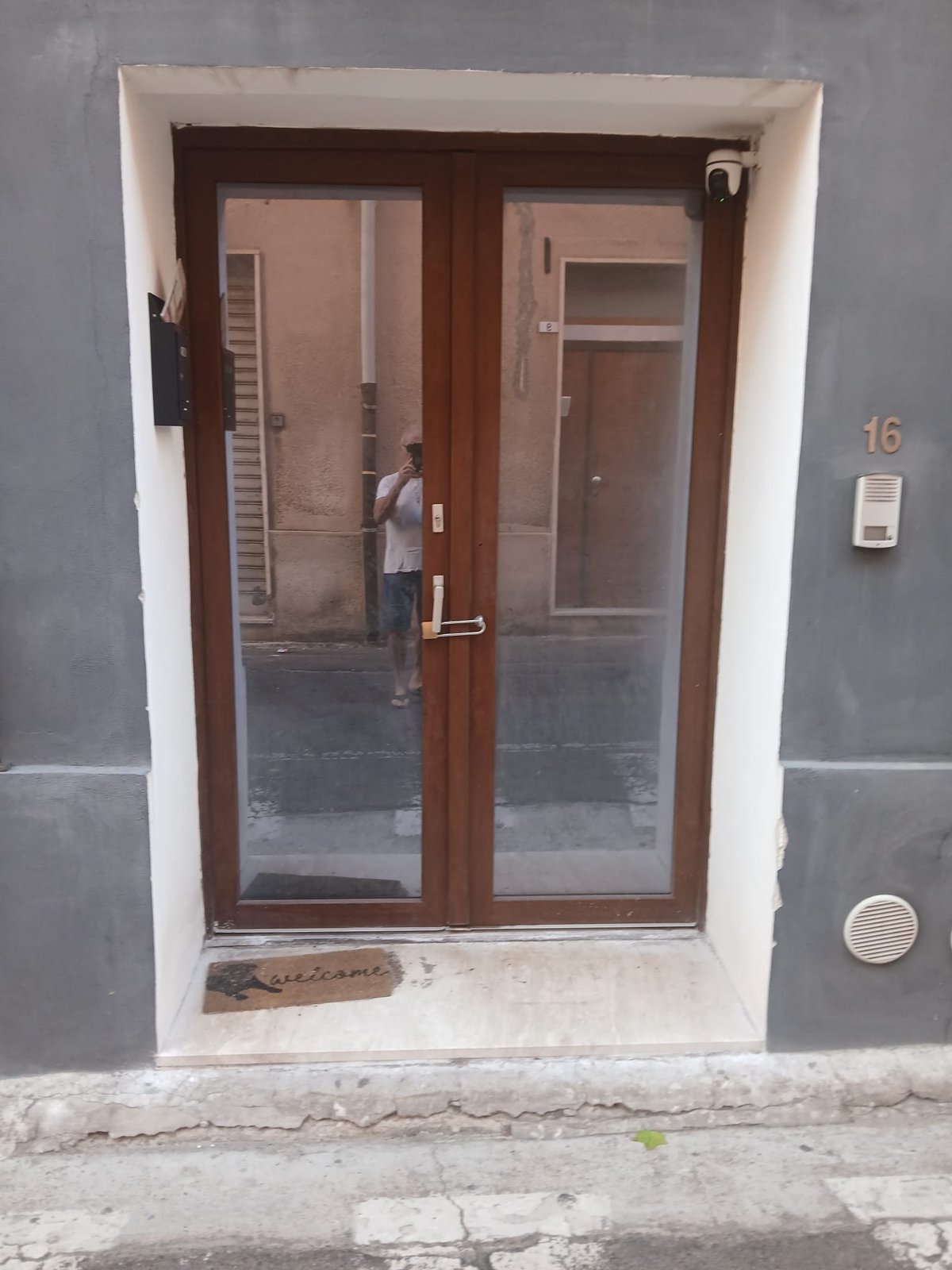 Porta finestra a due ante con telaio color legno scuro e vetri, vista dall'esterno